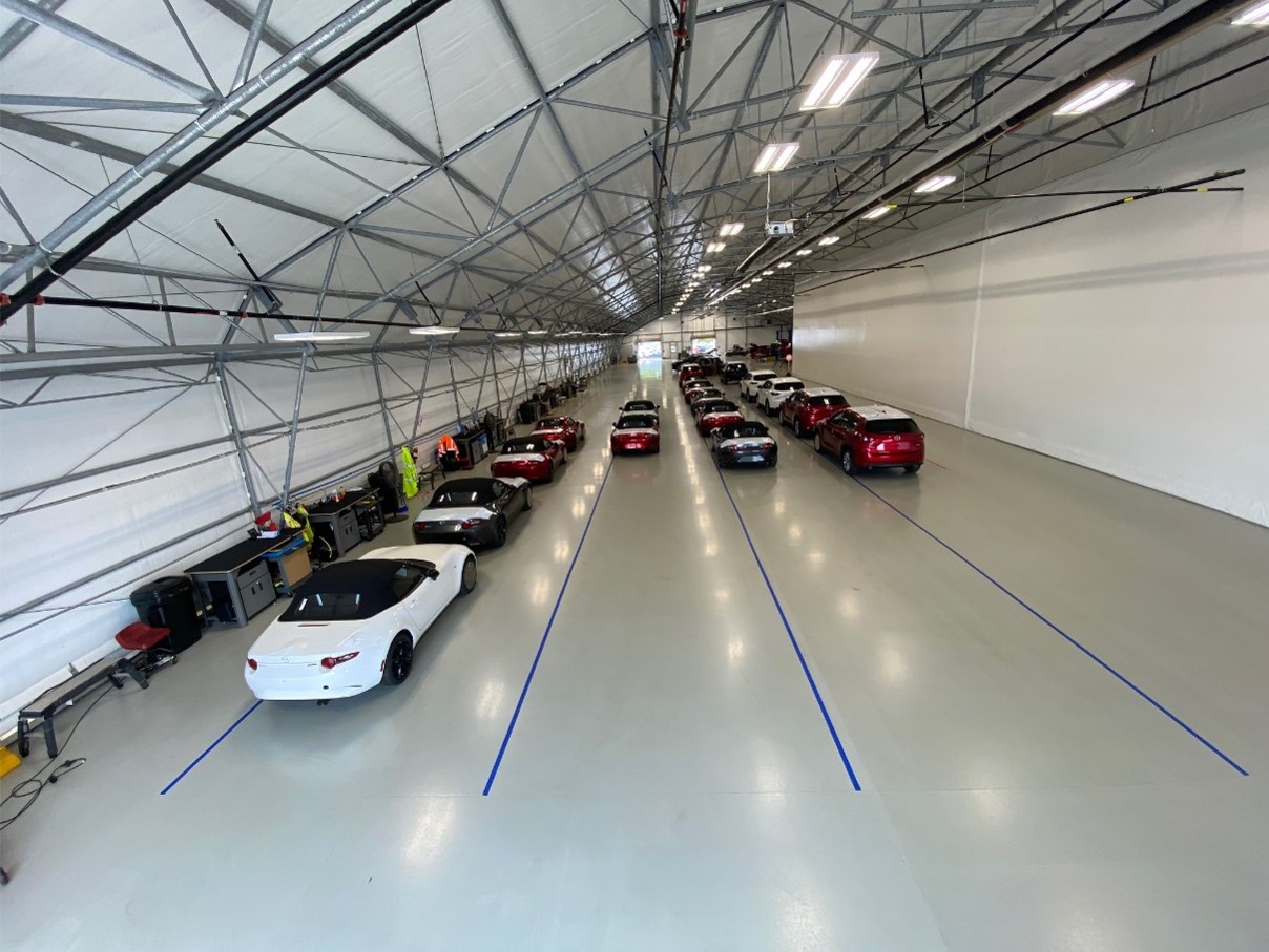 Wide angle shot of cars parked inside a vehicle staging facility