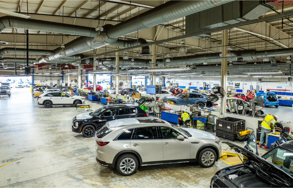 A wide-angle shot of busy activity inside a car repair garage
