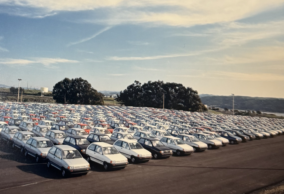 A vintage photo of a parking lot full of subcompact cars